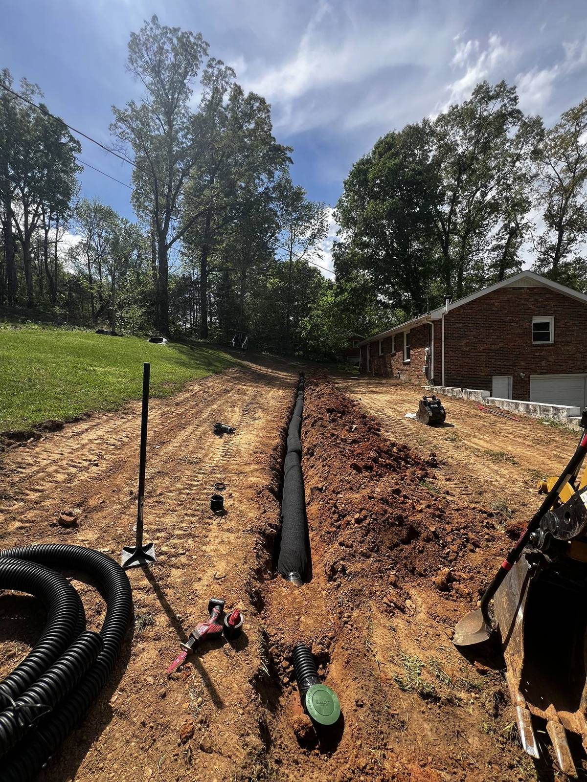 Perforated French drain pipe being installed by Michael Way Acres